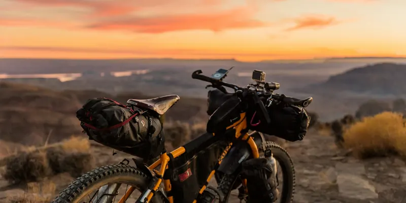 Bepacktes Mountainbike vor einem Abendhimmel über weiter Landschaft