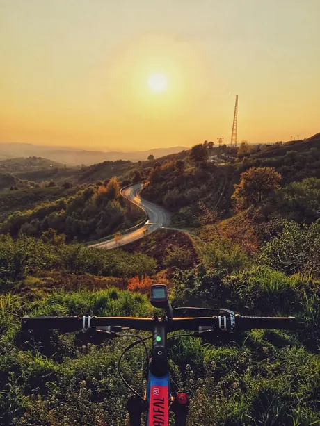 Blick über den Lenker eines Mountainbikes in den Sonnenuntergang