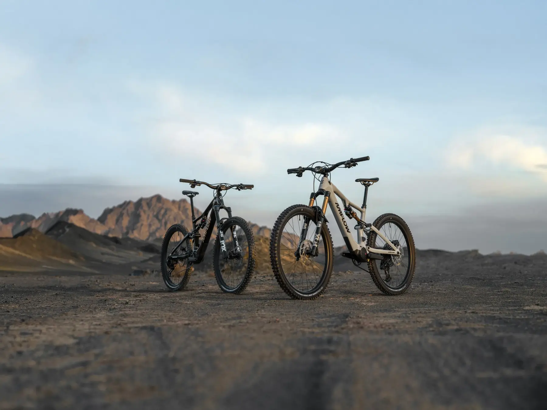 Zwei Amflow-E-Mountainbikes von Ramsauer Radsport vor einem Bergpanorama im Abendlicht