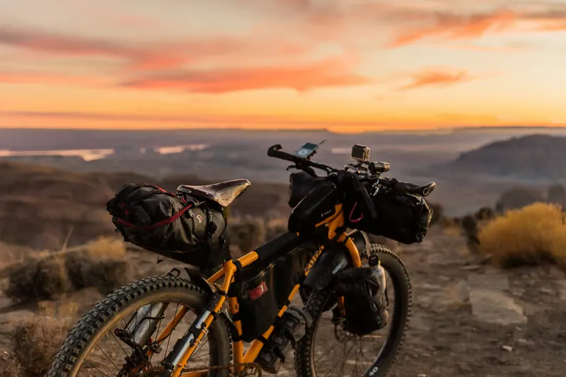 Bepacktes Mountainbike vor einem Abendhimmel über weiter Landschaft