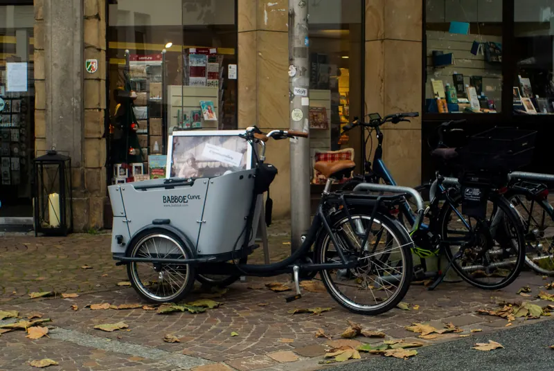 Weisses Cargo-Bike vor einem Ladenlokal in der Stadt