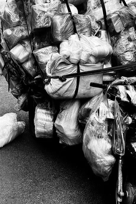 Schwarz-weiss: bepacktes Velo mit Säcken, Hochformat