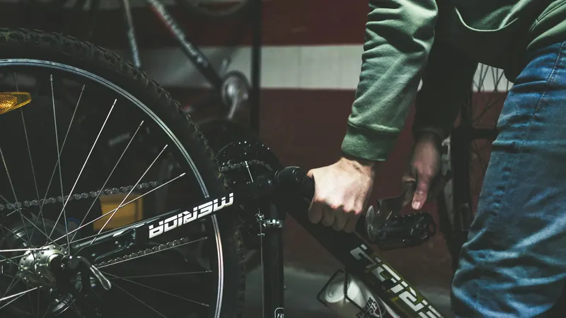 Hände arbeiten am Antrieb eines E-Bikes, dunkle Werkstattszene
