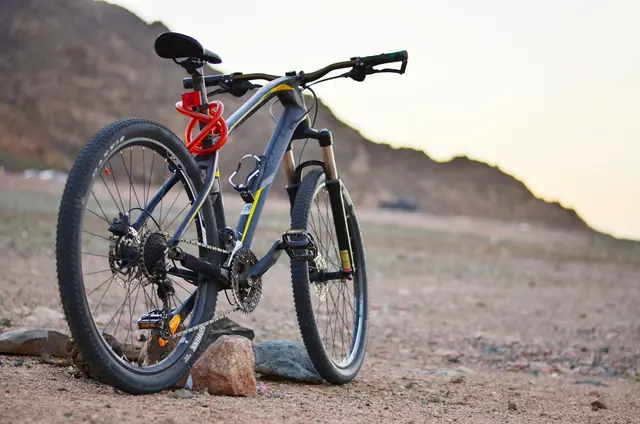 Mountainbike auf steinigem Untergrund vor einem Hügelzug