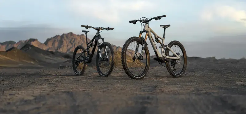 Zwei E-Bikes von Ramsauer Radsport auf einer Schotterpiste im Abendlicht