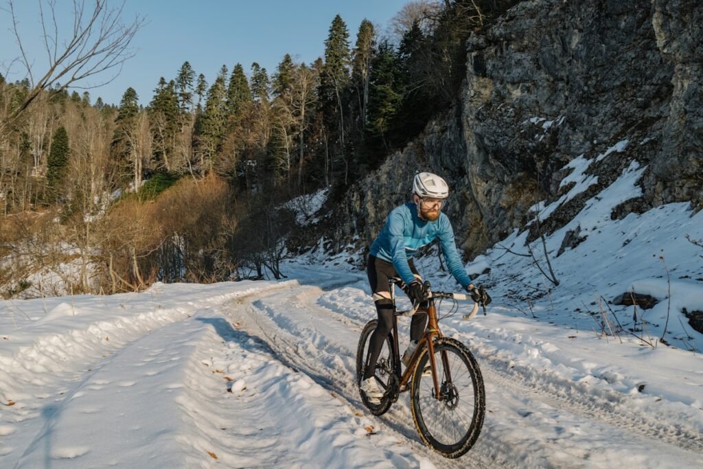Velofahrer auf verschneitem Weg — E-Bike im Winter